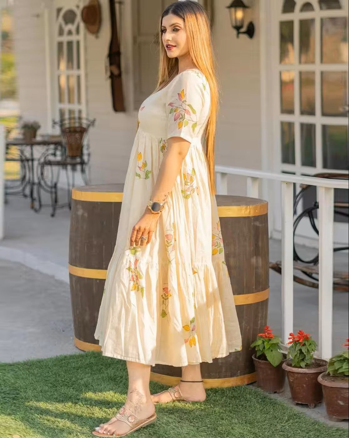Woman wearing aromie rust orange mini dress standing outdoors near wooden barrels and plants