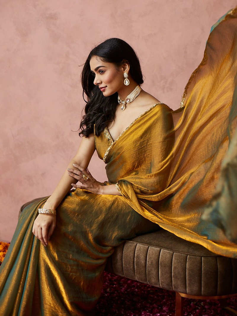 Gold-toned saree by Aromie in silk fabric, shown draped elegantly for festive occasions