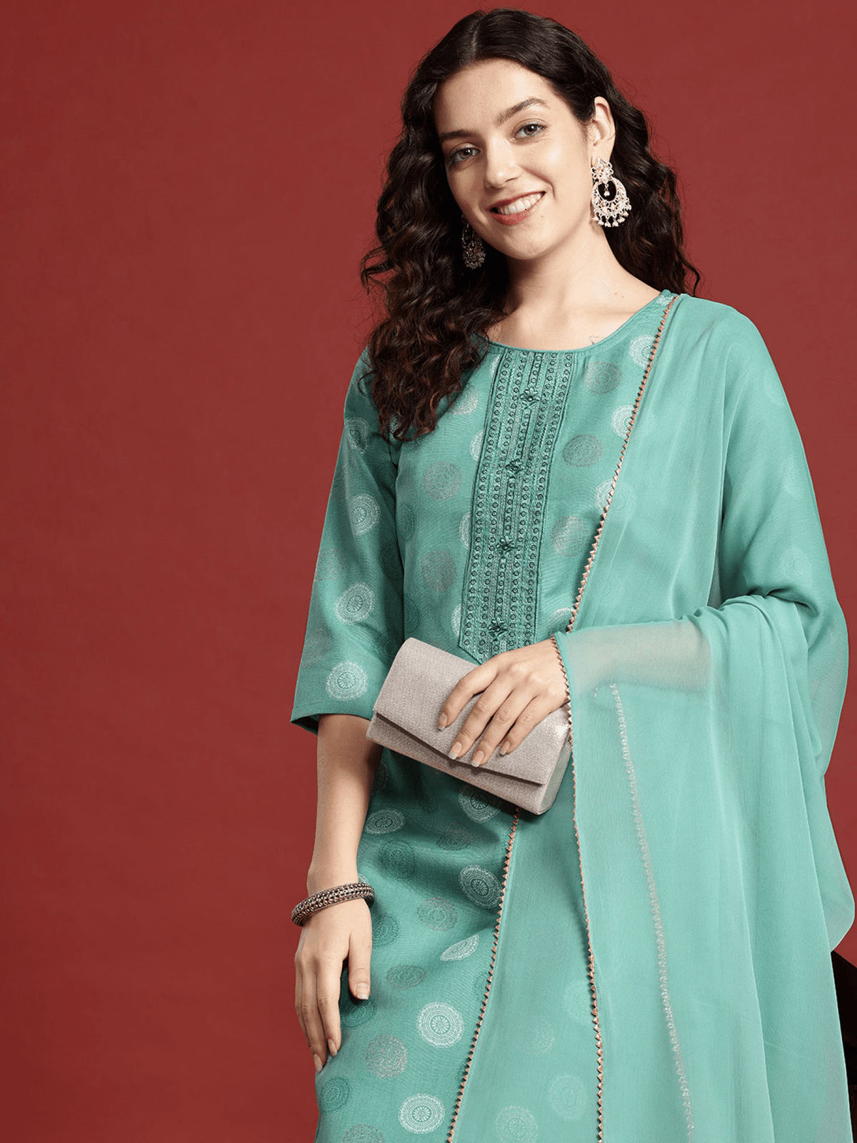Aromie sea green ethnic kurta set with intricate detailing, paired with a stylish clutch and accessories.