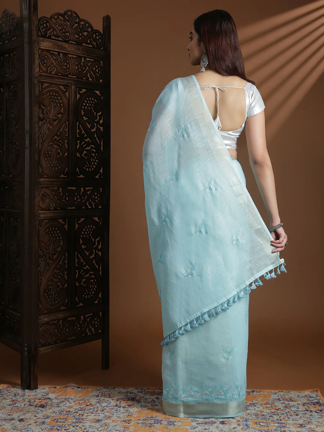 Light blue semi linen embroidered saree from Aromie, perfect for weddings, shown from the back with tassels