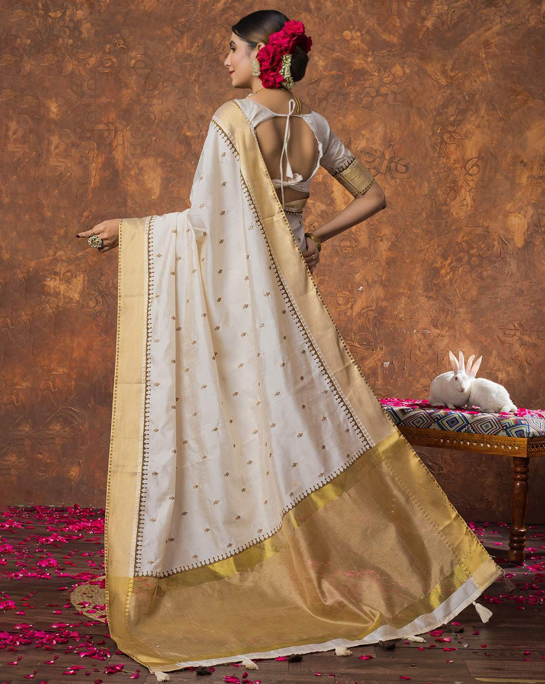 Aromie sequin embellished saree online with white and gold design worn by a woman with floral hair accessories