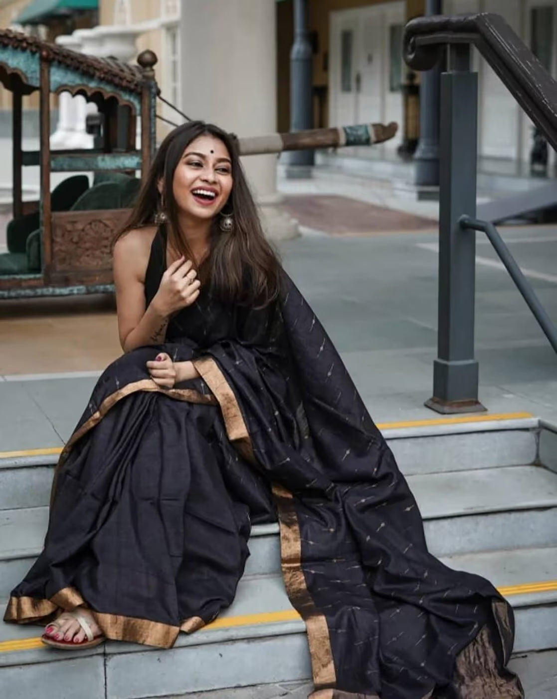 Elegant woman wearing a sequin embellished saree online, styled with vintage embroidery and traditional accessories.