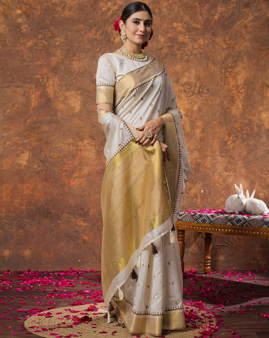 Woman wearing Aromie sequin embellished saree online in white and gold with traditional jewelry