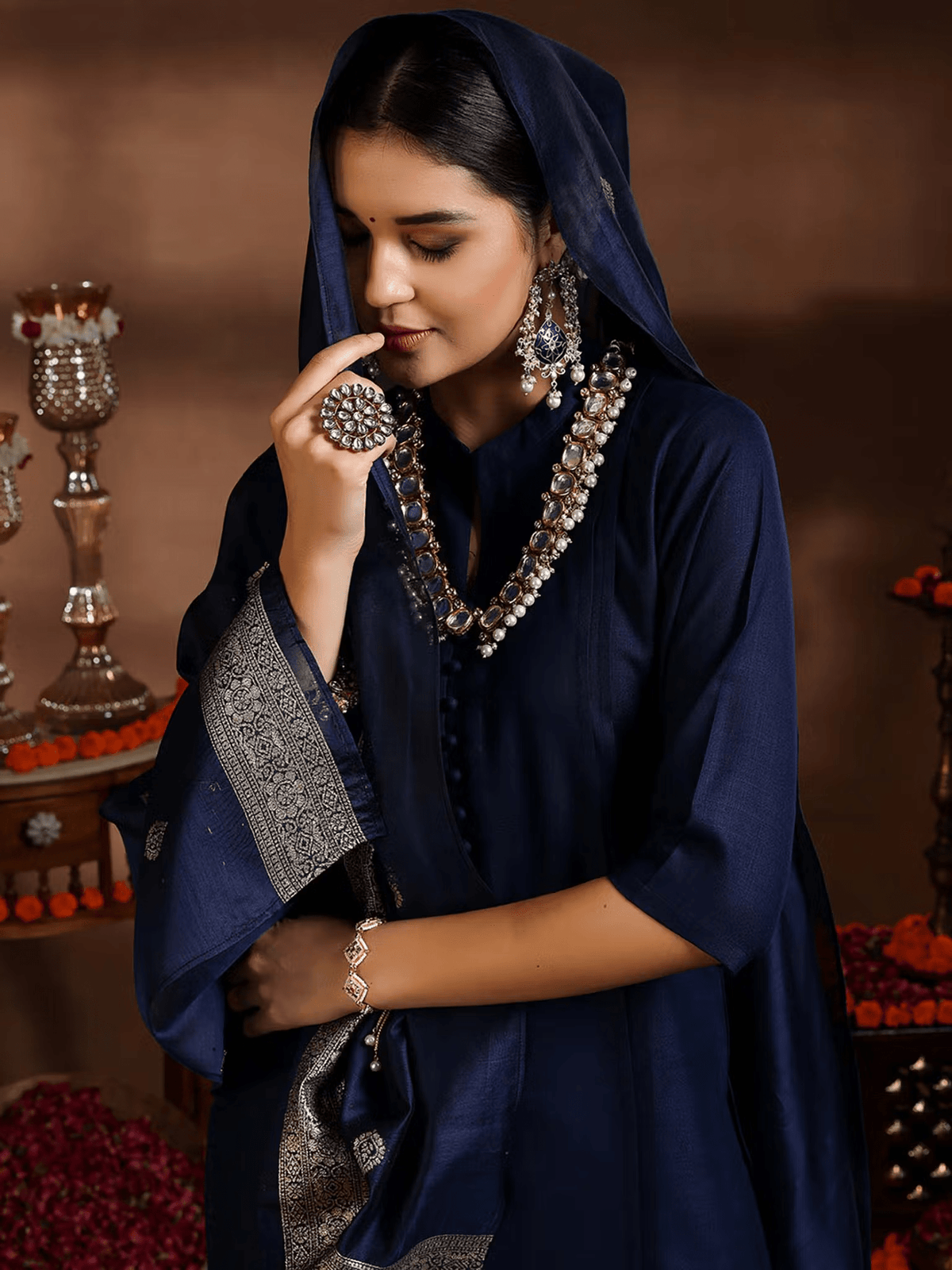 Elegant silk blend kurta set in navy blue with intricate embellishments and stylish accessories