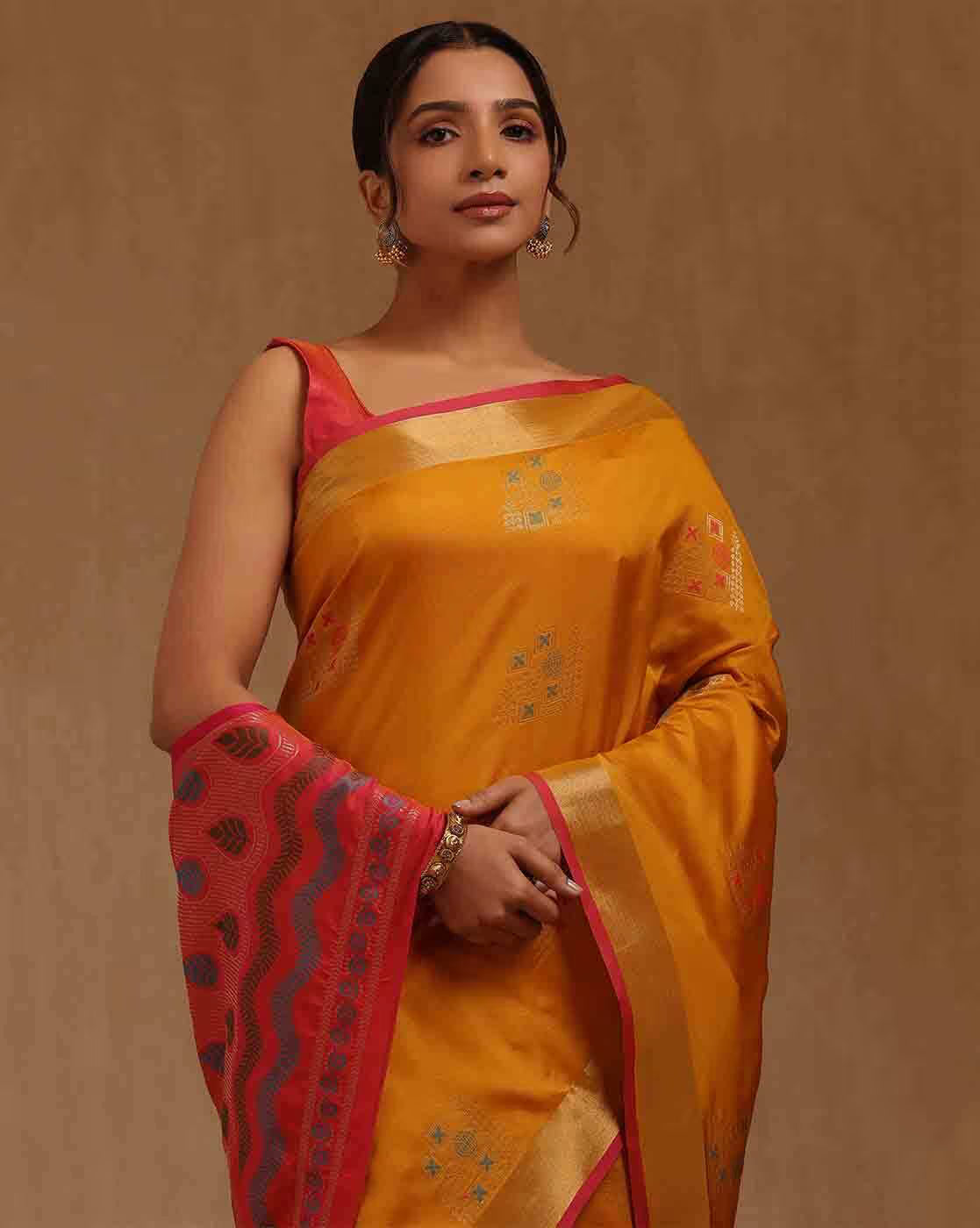 Front view of a vibrant orange silk blend saree Canda with intricate patterns, perfect for festive occasions