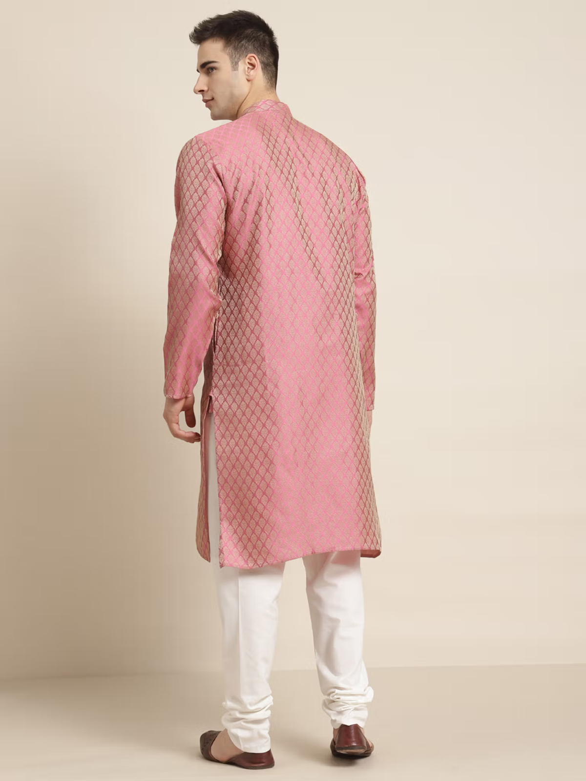 Man wearing mens pink silk kurta set Canada back view patterned silk kurta with white churidar and brown shoes