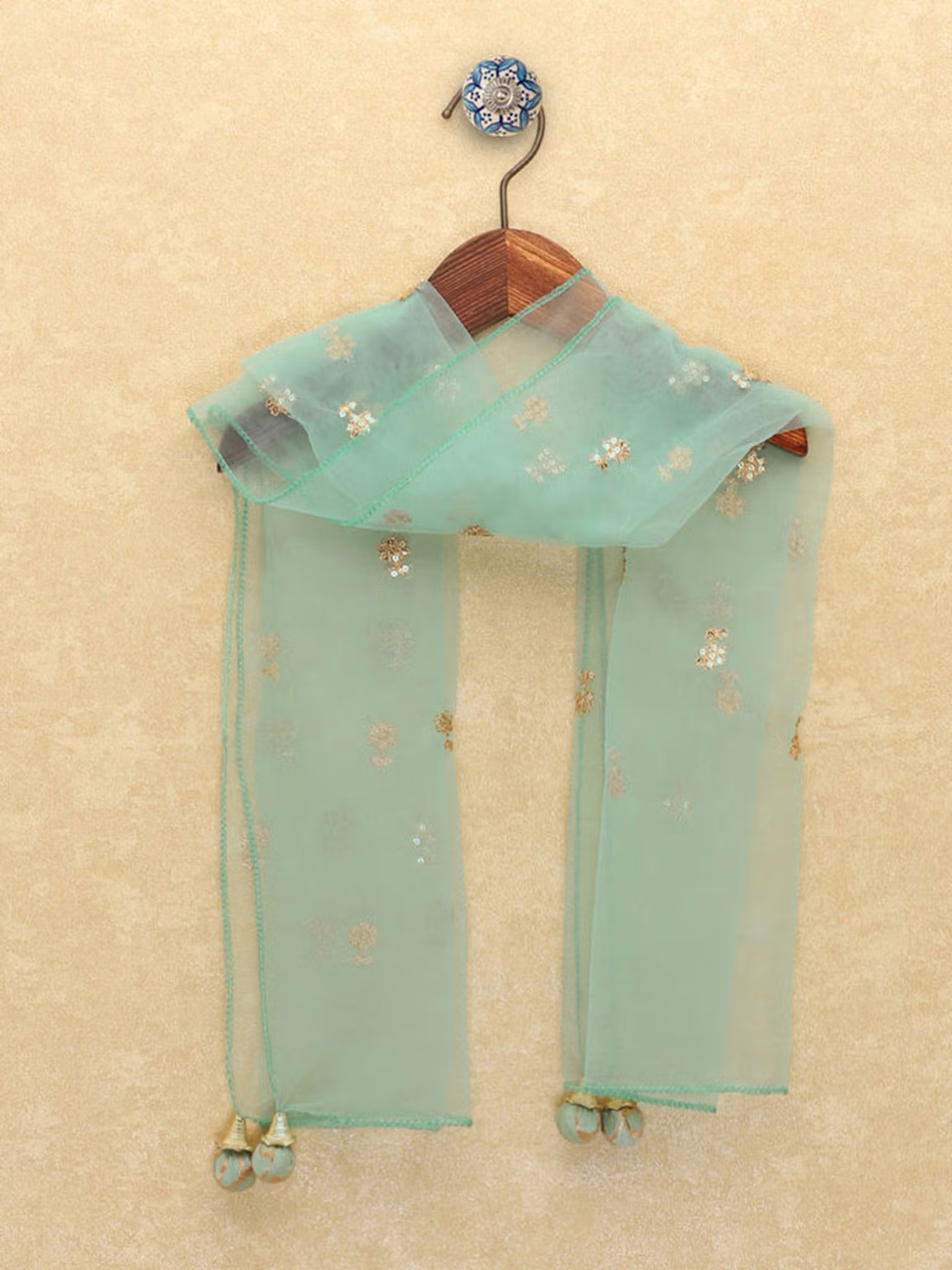 Sheer mint dupatta with gold leaf motifs and tassel ends on wooden hanger green leaf printed kurta palazzo dupatta set