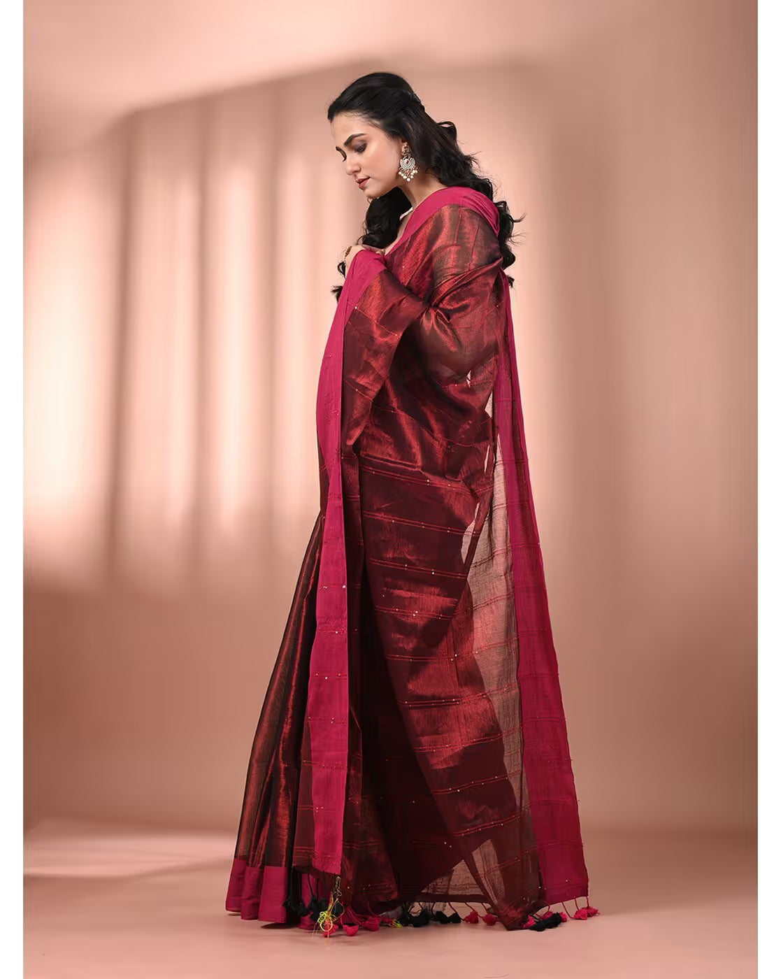 Maroon tissue saree from Aromie with elegant detailing, ideal for festive occasions, view from the side