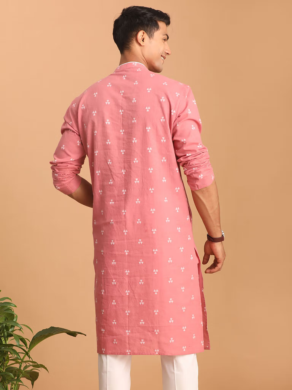 mens pink cotton kurta with small white motifs back view long sleeves rolled up paired with white pants