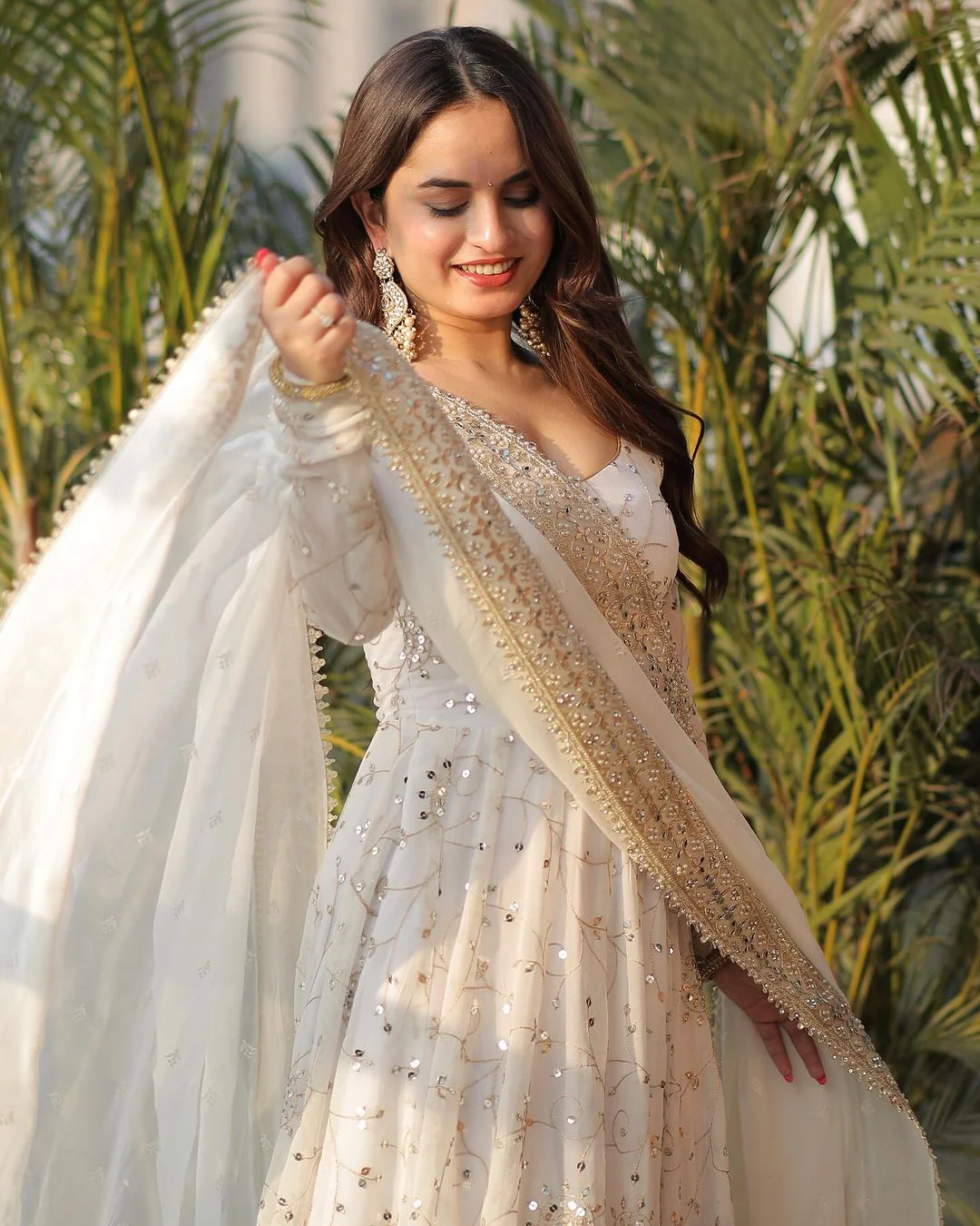 Three piece Kurtha featuring a white georgette anarkali gown with elegant embellishments and a flowing dupatta